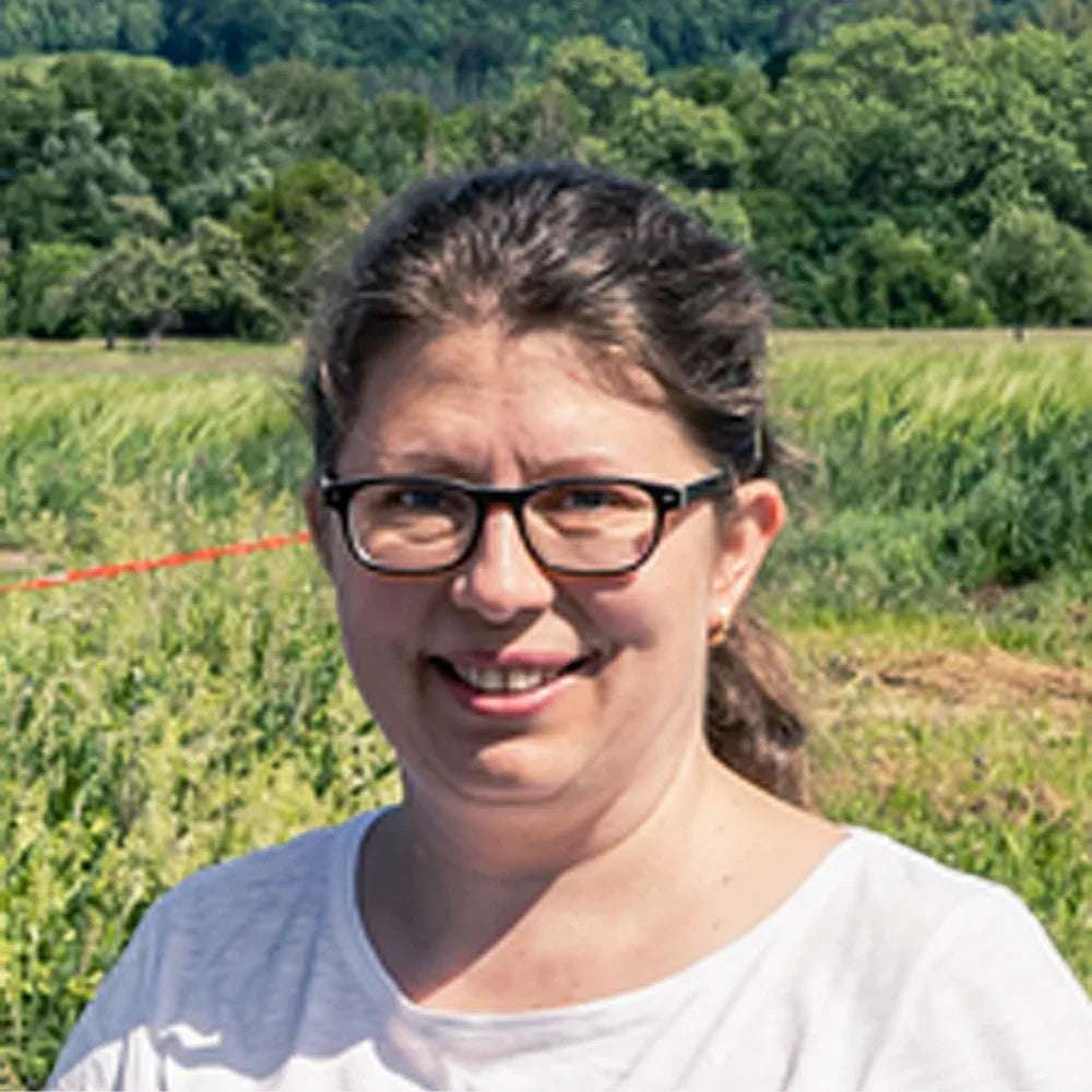 Porträt von Angelika Kauderer, Geschäftsführung, im Freien vor grünem Hintergrund.