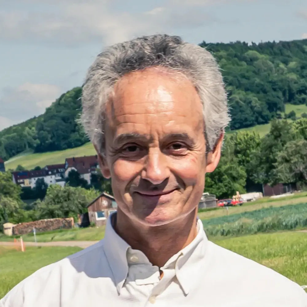 Porträt von Albrecht Kauderer, Geschäftsführer, im Freien vor ländlichem Hintergrund.