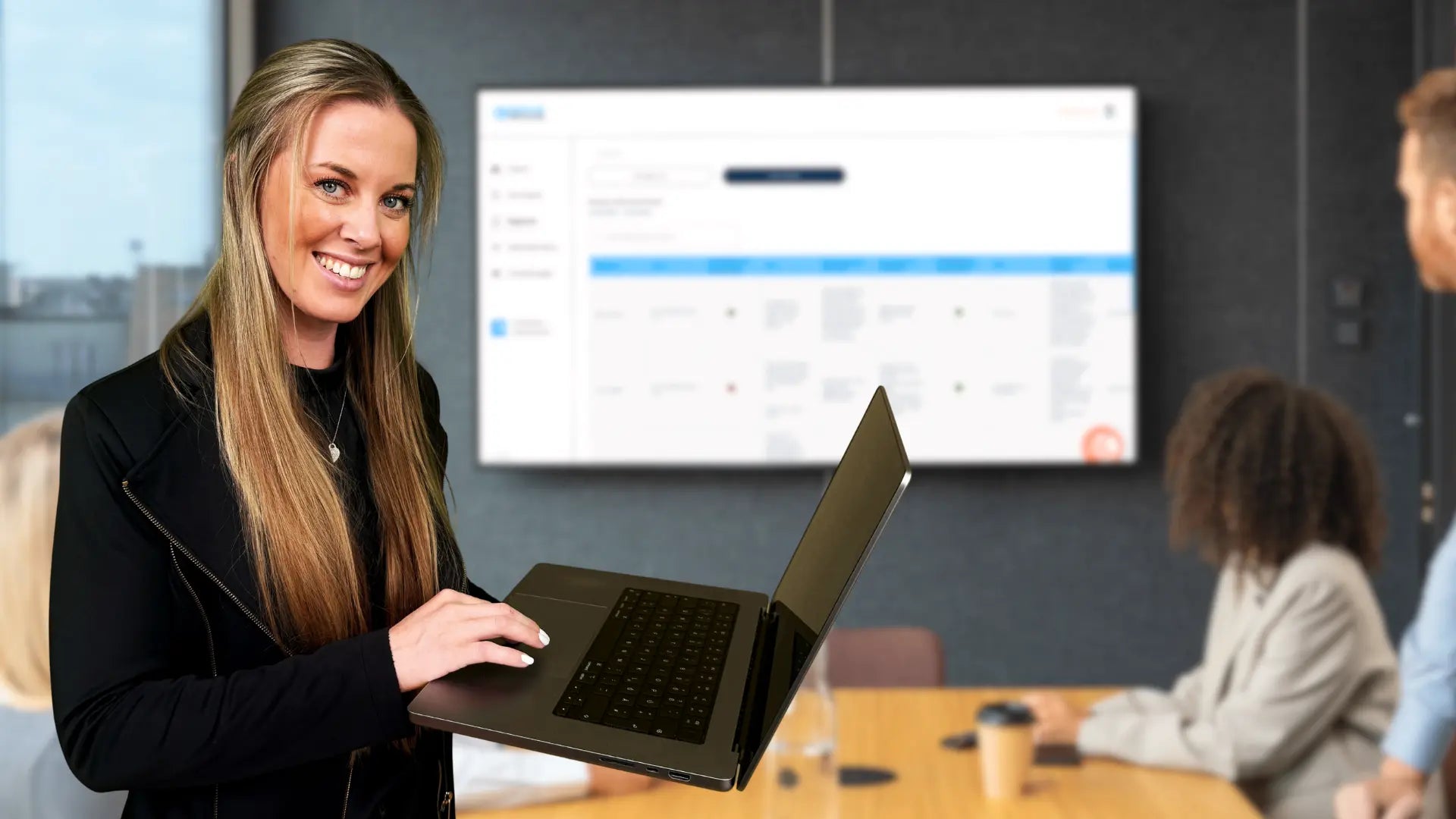 Alina Klejbor mit Laptop vor einem Unternehmer Cockpit im Besprechungsraum, digitale Steuerung von Aufgaben, Planung und Unternehmensführung mit Lösungen der Erfolgsimpulse GmbH.