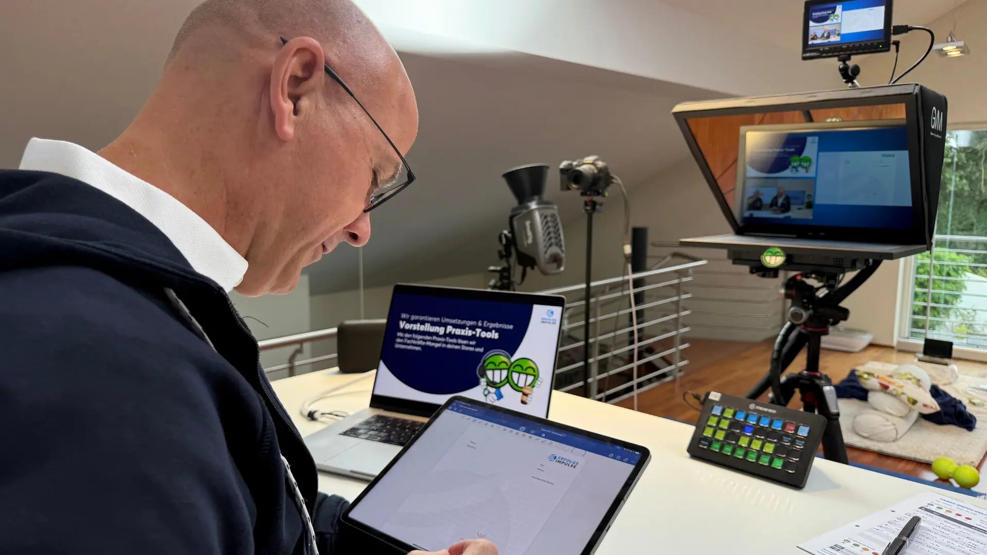 Marc Klejbor im Studio der Erfolgsimpulse GmbH bei der Vorbereitung einer digitalen Präsentation, mit Tablet, Laptop, Kamera Setup und professionellem Online Coaching Equipment.