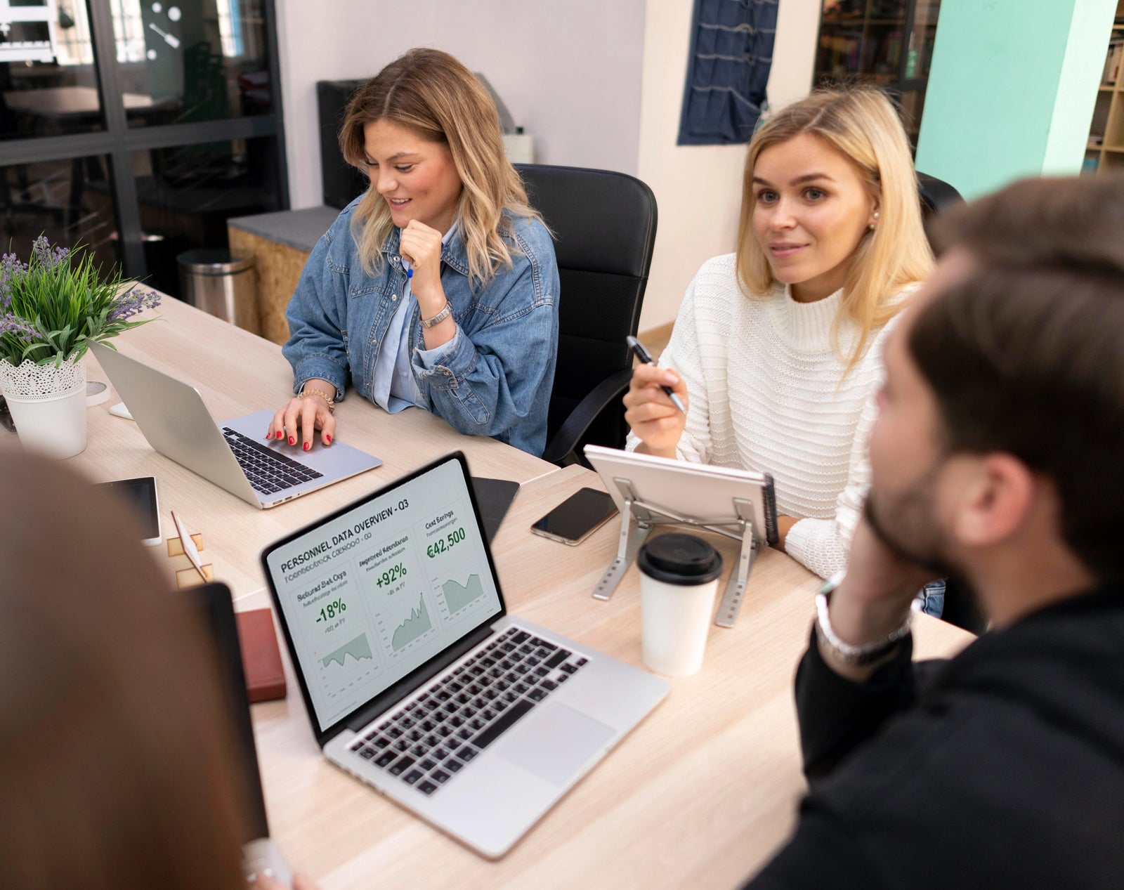 Team Meeting im Büro mit Laptop und KPI Dashboard auf dem Bildschirm, gemeinsame Auswertung von Kennzahlen und Strategie Arbeit im Kontext der Erfolgsimpulse GmbH.