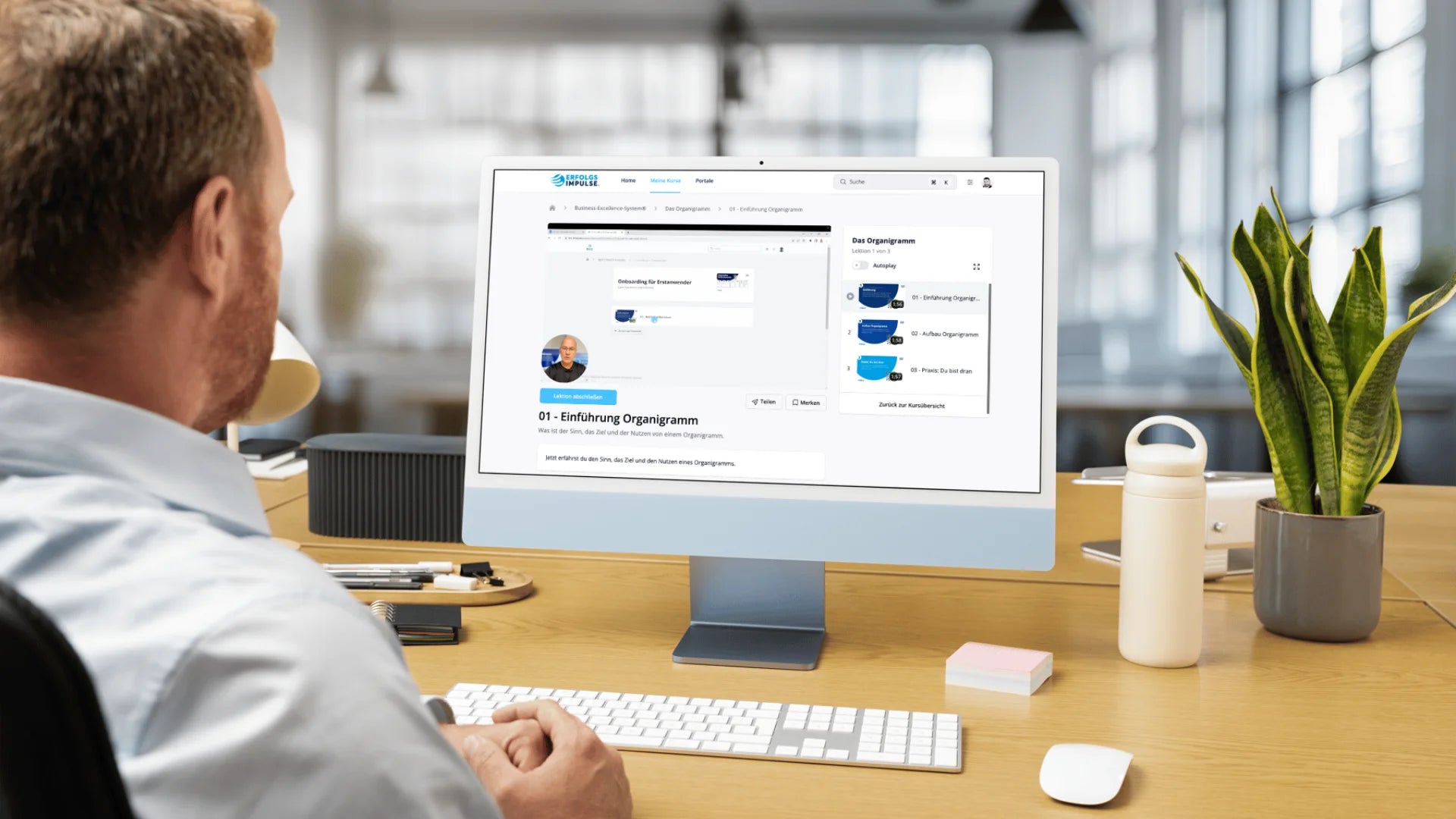 Unternehmer im Büro nutzt die Erfolgsimpulse Academy am Desktop, digitales Lernmodul zum Organigramm für strukturierte Unternehmensführung und klare Prozesse.