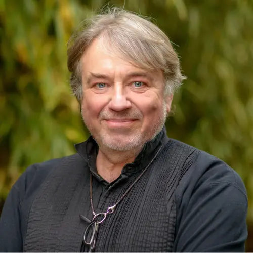 Porträt von Klaus Kobjoll, Vollblut Unternehmer, vor grünem Hintergrund.